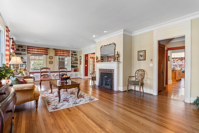 915 W Clark St, Champaign, IL 61821 - living room with wood finished floors, a fireplace, ornamental molding, built in shelves, and baseboards