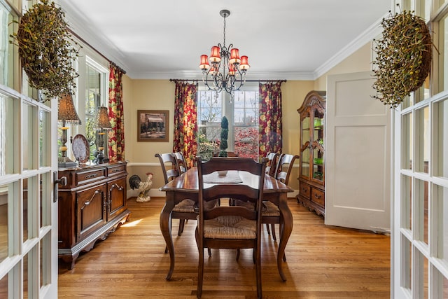 915 W Clark St, Champaign, IL 61821 - dining room with a chandelier, light wood-style floors, crown molding, plenty of natural light, and french doors