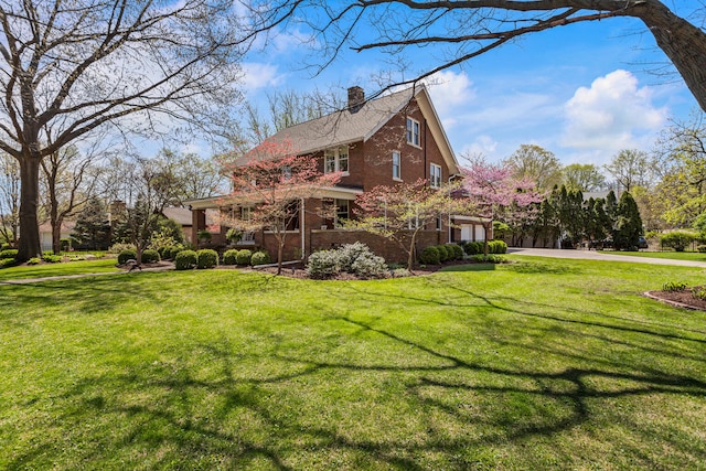 915 W Clark St, Champaign, IL 61821 - view of side of home with driveway, a chimney, brick siding, and a yard