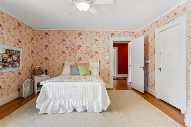 915 W Clark St, Champaign, IL 61821 - bedroom with wood finished floors, wallpapered walls, baseboards, and ceiling fan