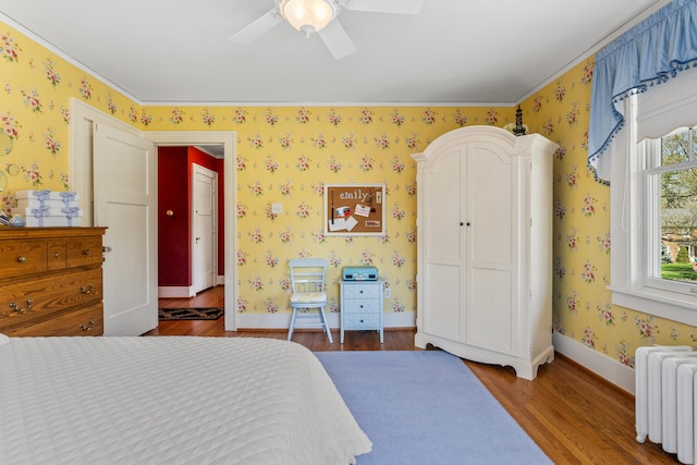 915 W Clark St, Champaign, IL 61821 - bedroom with radiator heating unit, wood finished floors, wallpapered walls, ceiling fan, and baseboards