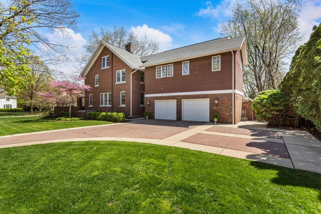 915 W Clark St, Champaign, IL 61821 - view of front of house with driveway, an attached garage, brick siding, a front yard, and a chimney