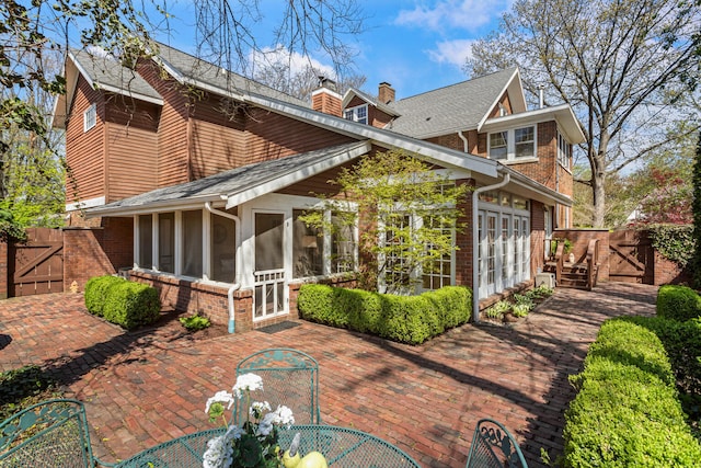 915 W Clark St, Champaign, IL 61821 - rear view of house with a gate, a sunroom, a patio area, and brick siding