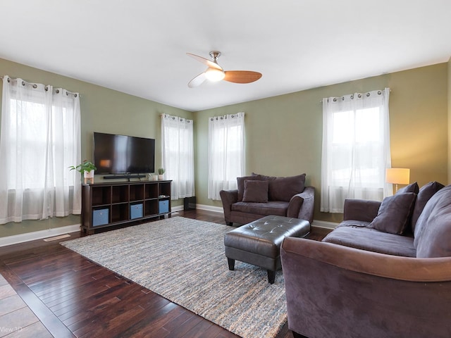 living room with baseboards, dark wood-style flooring, ceiling fan, and visible vents