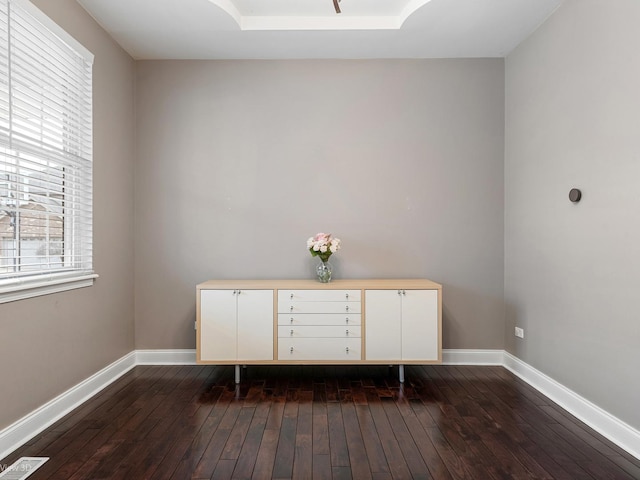 interior space featuring dark wood-type flooring, baseboards, and visible vents