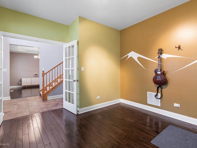 interior space with visible vents, baseboards, wood finished floors, and french doors
