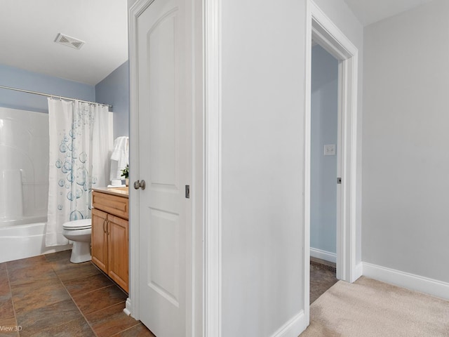 full bath featuring visible vents, shower / bath combo, vanity, baseboards, and toilet