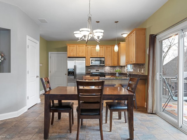 dining space featuring baseboards, visible vents, and a notable chandelier