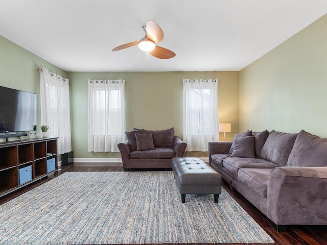 living room with dark wood-type flooring, baseboards, and ceiling fan