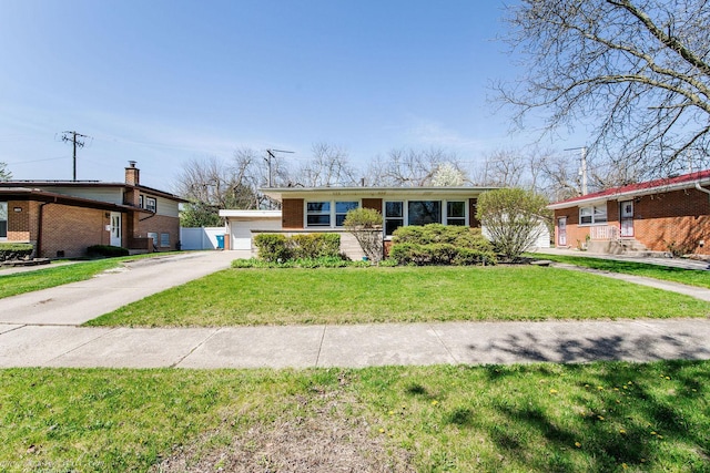 view of front of home with a garage, brick siding, and a front lawn