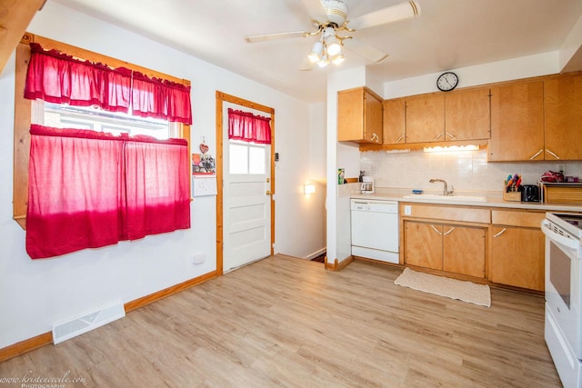 kitchen featuring white appliances, light wood-style floors, light countertops, a sink, and visible vents