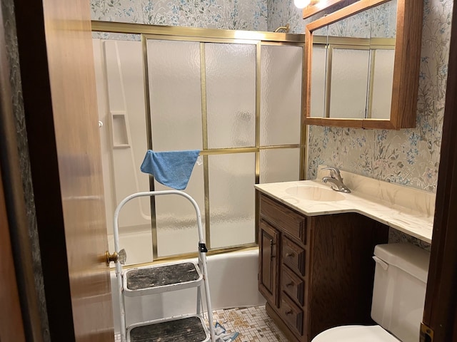 full bathroom featuring wallpapered walls, combined bath / shower with glass door, and toilet