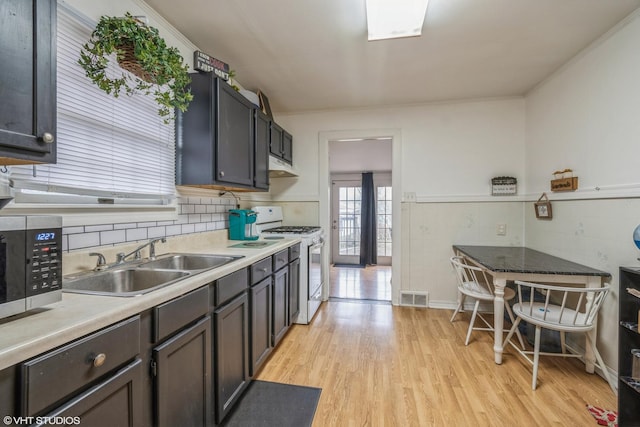 241 Tiverton Ln, Steger, IL 60475 - kitchen featuring a sink, stainless steel microwave, under cabinet range hood, visible vents, and white range with gas cooktop