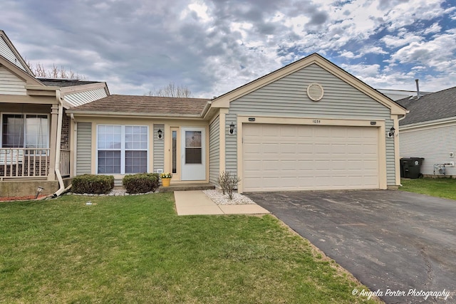 single story home with an attached garage, a front lawn, and driveway