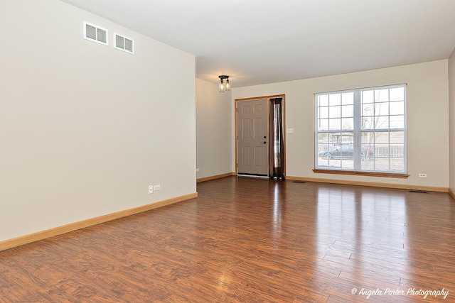 interior space with wood finished floors, visible vents, and baseboards