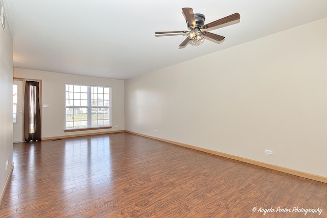 spare room featuring wood finished floors, visible vents, baseboards, and ceiling fan