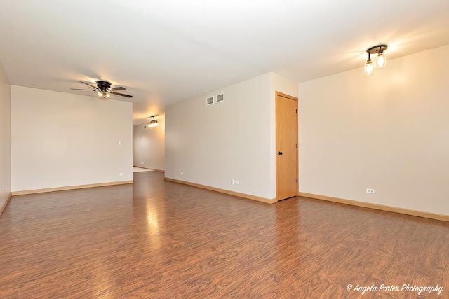 unfurnished room with wood finished floors, baseboards, a ceiling fan, and visible vents