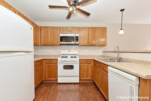 kitchen featuring light countertops, white appliances, a sink, and tasteful backsplash