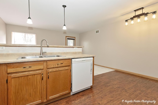 kitchen featuring white dishwasher, a sink, dark wood finished floors, backsplash, and visible vents