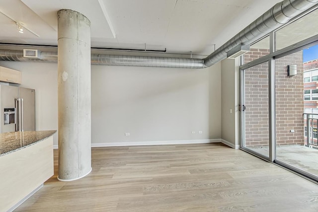 basement featuring light wood-type flooring, baseboards, visible vents, and high end refrigerator