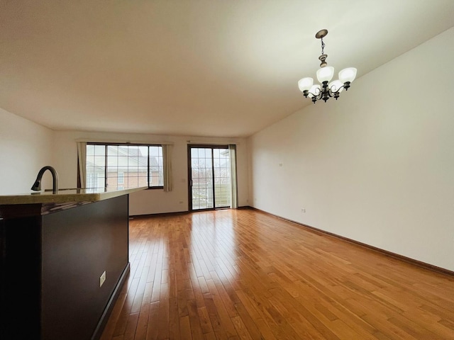 15753 Scotsglen Rd, Orland Park, IL 60462 - empty room featuring wood finished floors, baseboards, and an inviting chandelier