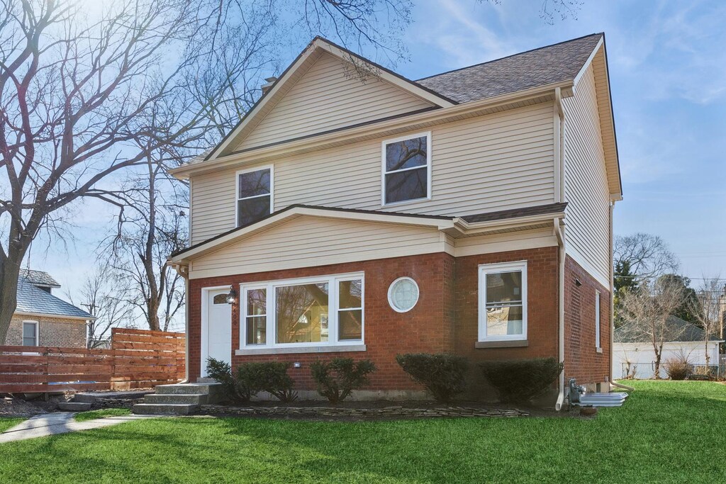 1400 Cleveland St, Evanston, IL 60202 - american foursquare style home with a front lawn, brick siding, and fence