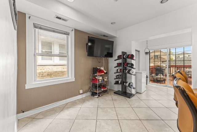 interior space featuring baseboards, light tile patterned flooring, and visible vents