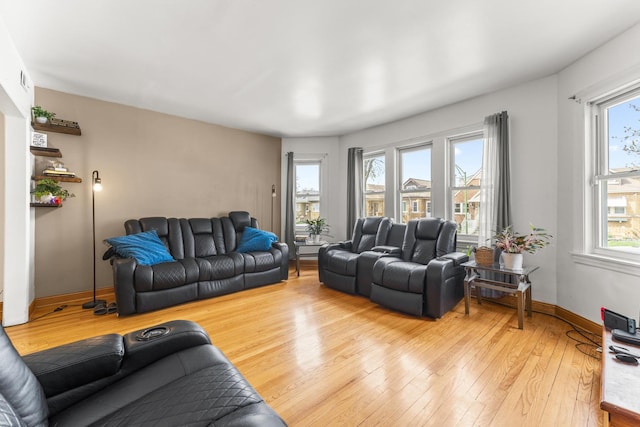 living room with a healthy amount of sunlight, light wood finished floors, and baseboards