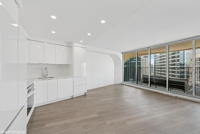 300 N State St Unit 3827, Chicago, IL 60654 - unfurnished living room with light wood finished floors, expansive windows, a sink, and recessed lighting