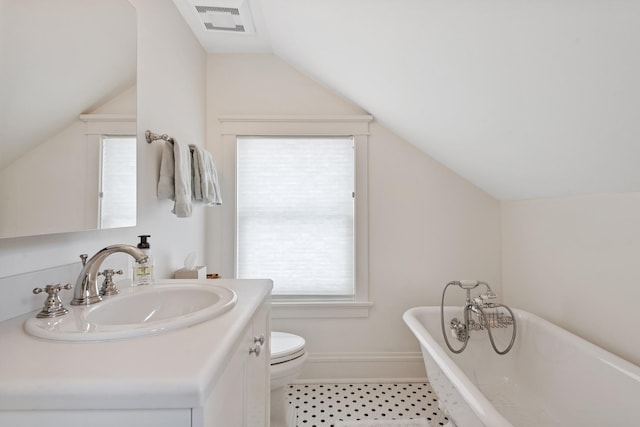938 Edgemere Ct, Evanston, IL 60202 - bathroom with vaulted ceiling, a soaking tub, toilet, vanity, and baseboards