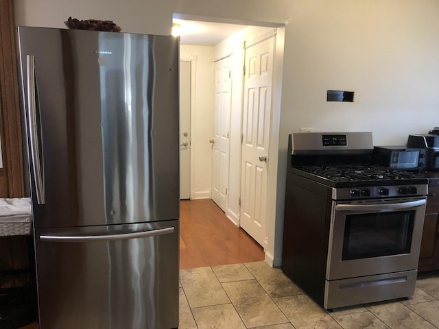926 S Lathrop Ave, Forest Park, IL 60130 - kitchen with light tile patterned floors and stainless steel appliances