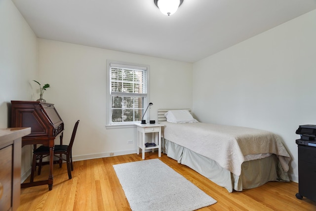 bedroom with light wood finished floors and baseboards