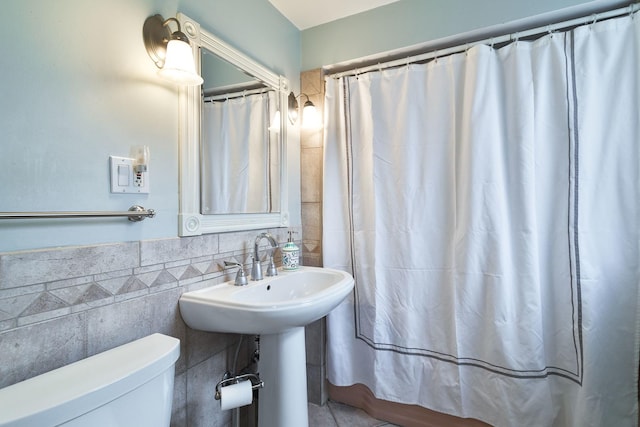 full bathroom with tile walls, toilet, and a shower with curtain