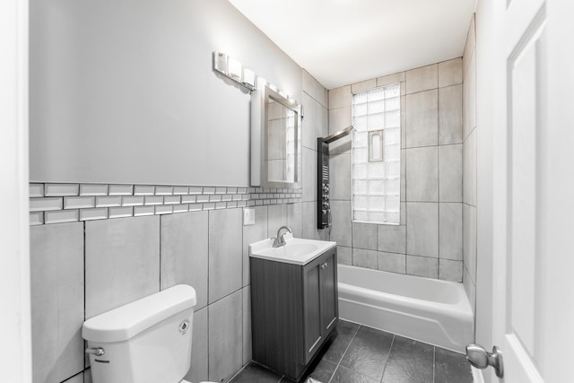 full bathroom with tile patterned floors, bathing tub / shower combination, toilet, vanity, and tile walls