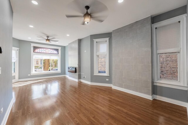 unfurnished living room featuring baseboards, a ceiling fan, wood finished floors, and recessed lighting