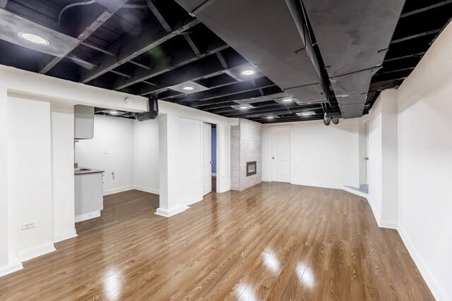 finished below grade area with baseboards and wood finished floors