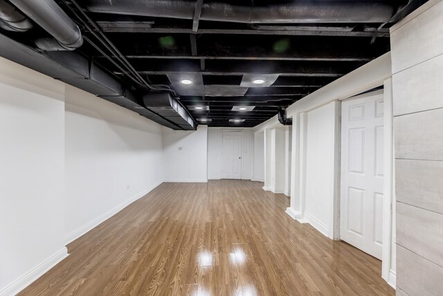 finished basement with baseboards and wood finished floors