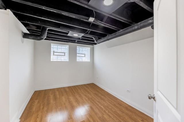 basement with baseboards and wood finished floors