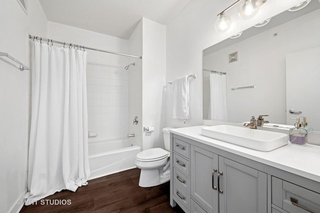 bathroom with wood finished floors, toilet, vanity, and shower / bath combo with shower curtain