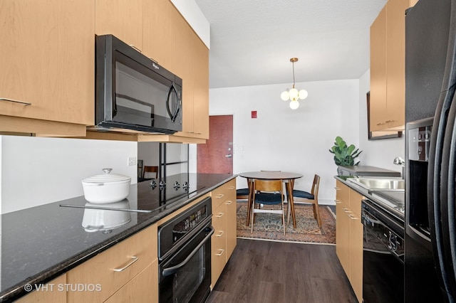 kitchen featuring black appliances, dark wood-style floors, a sink, light brown cabinetry, and dark stone counters