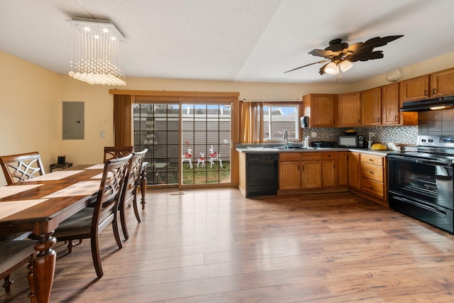 5118 Carol Ln, Gurnee, IL 60031 - kitchen with a sink, brown cabinetry, black appliances, light wood-style floors, and under cabinet range hood