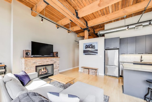 living room with visible vents, track lighting, wood ceiling, and light wood-style floors