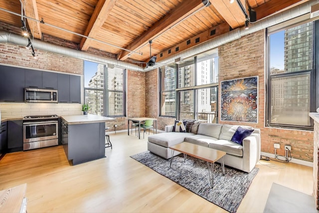 living room featuring light wood-style floors, beam ceiling, brick wall, and wooden ceiling