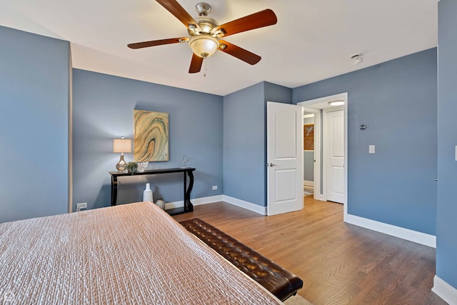 bedroom featuring baseboards, a ceiling fan, and wood finished floors