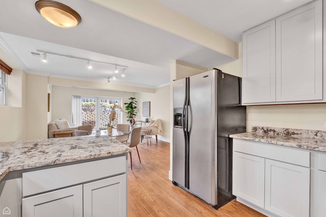 kitchen featuring stainless steel fridge, open floor plan, light wood-style flooring, and light stone countertops