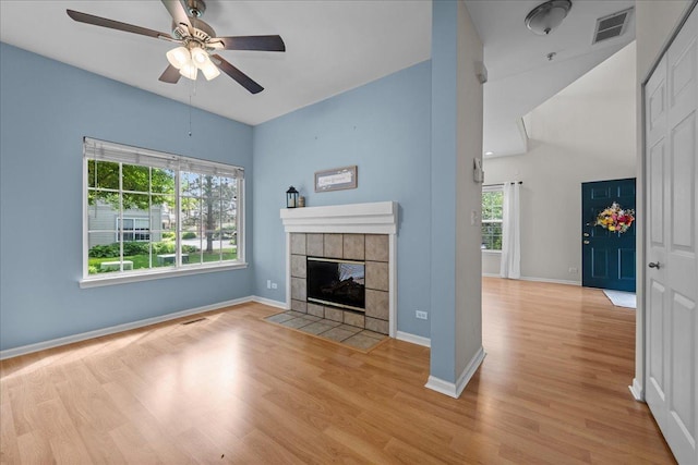 unfurnished living room featuring ceiling fan, light wood finished floors, baseboards, a fireplace, and high vaulted ceiling