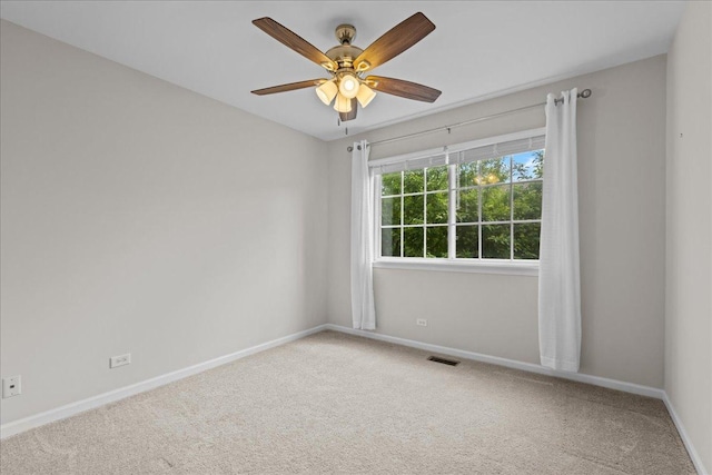 carpeted spare room with baseboards and ceiling fan