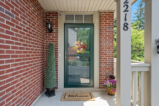 property entrance with brick siding and covered porch