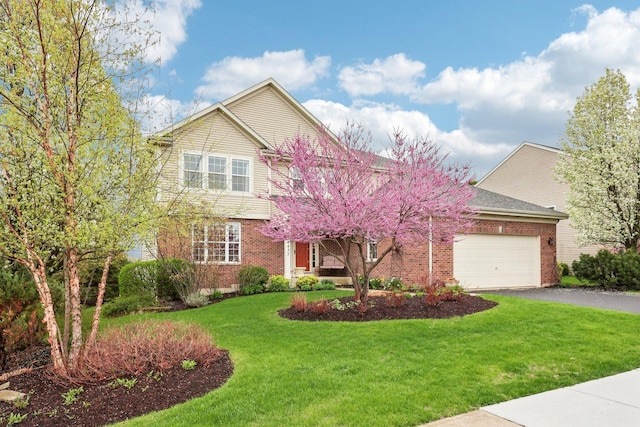 34457 N Bluestem Rd, Round Lake, IL 60073 - view of front facade featuring a garage, a front yard, aphalt driveway, and brick siding