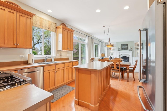 34457 N Bluestem Rd, Round Lake, IL 60073 - kitchen featuring appliances with stainless steel finishes, a center island, a fireplace, a sink, and light countertops